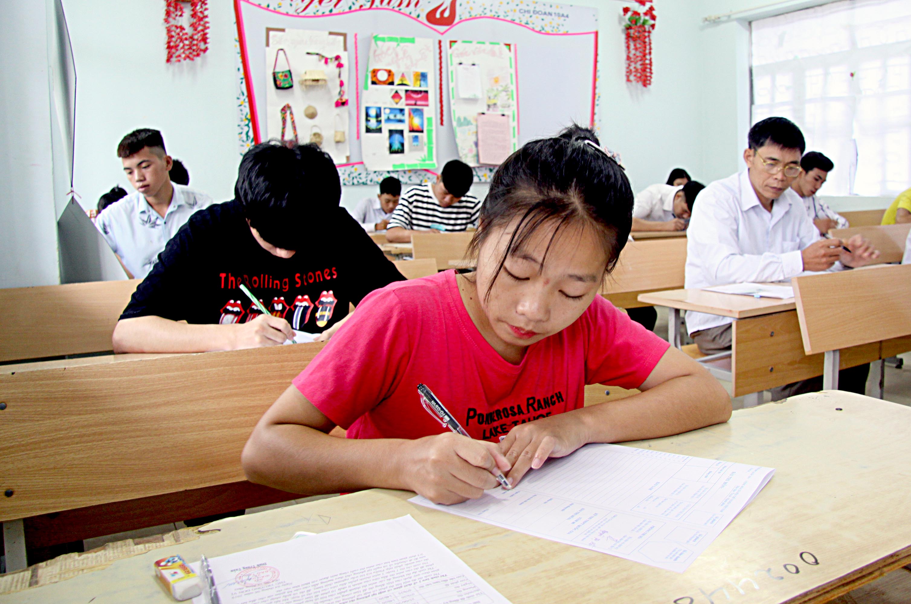 Thí sinh tại điểm thi Trường THPT Than Uyên (huyện Than Uyên) điền thông tin cá nhân vào giấy thi.