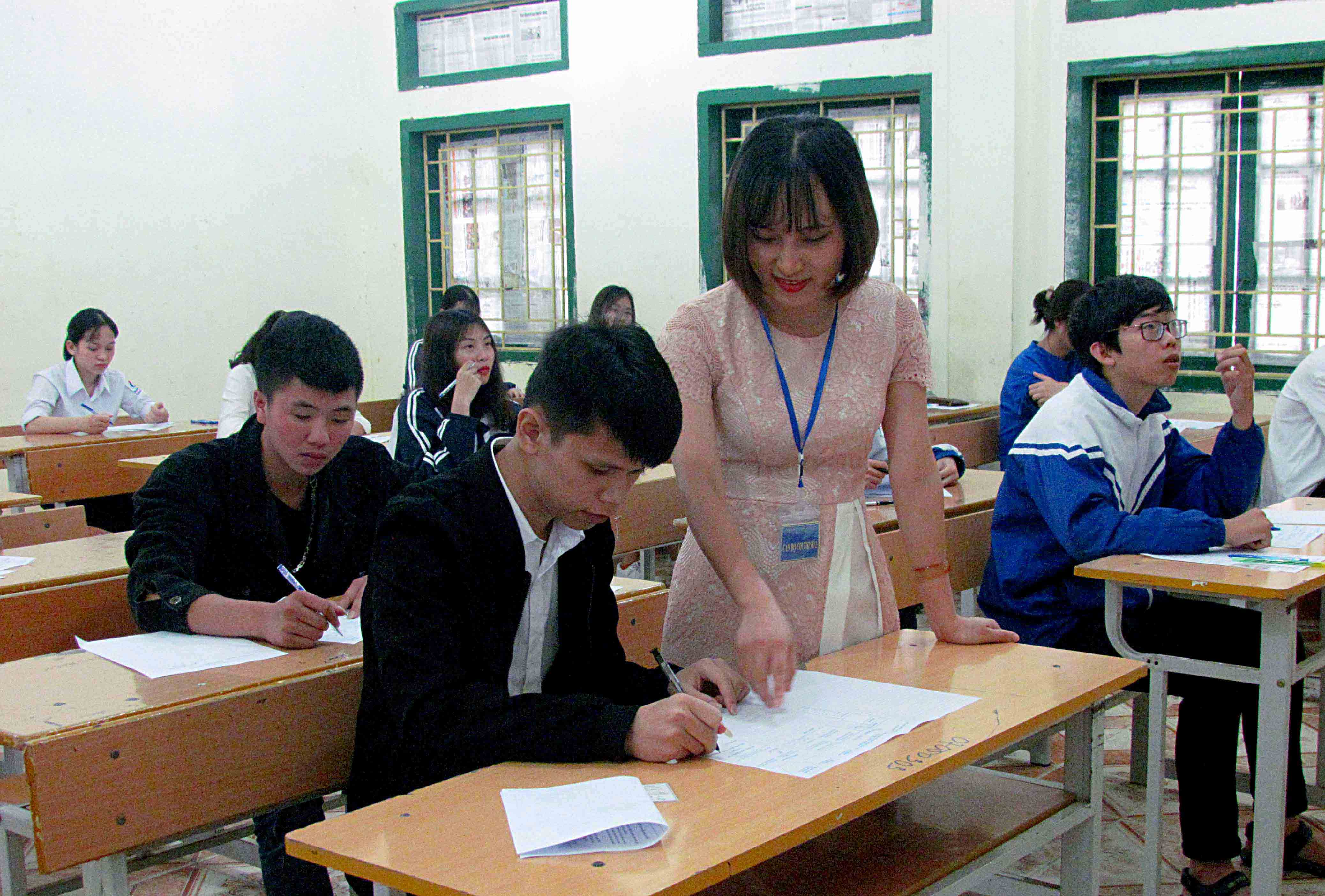 Cán bộ coi thi điểm thi Trường THPT thành phố (thành phố Lai Châu) hướng dẫn thí sinh điền thông tin trước khi thi.