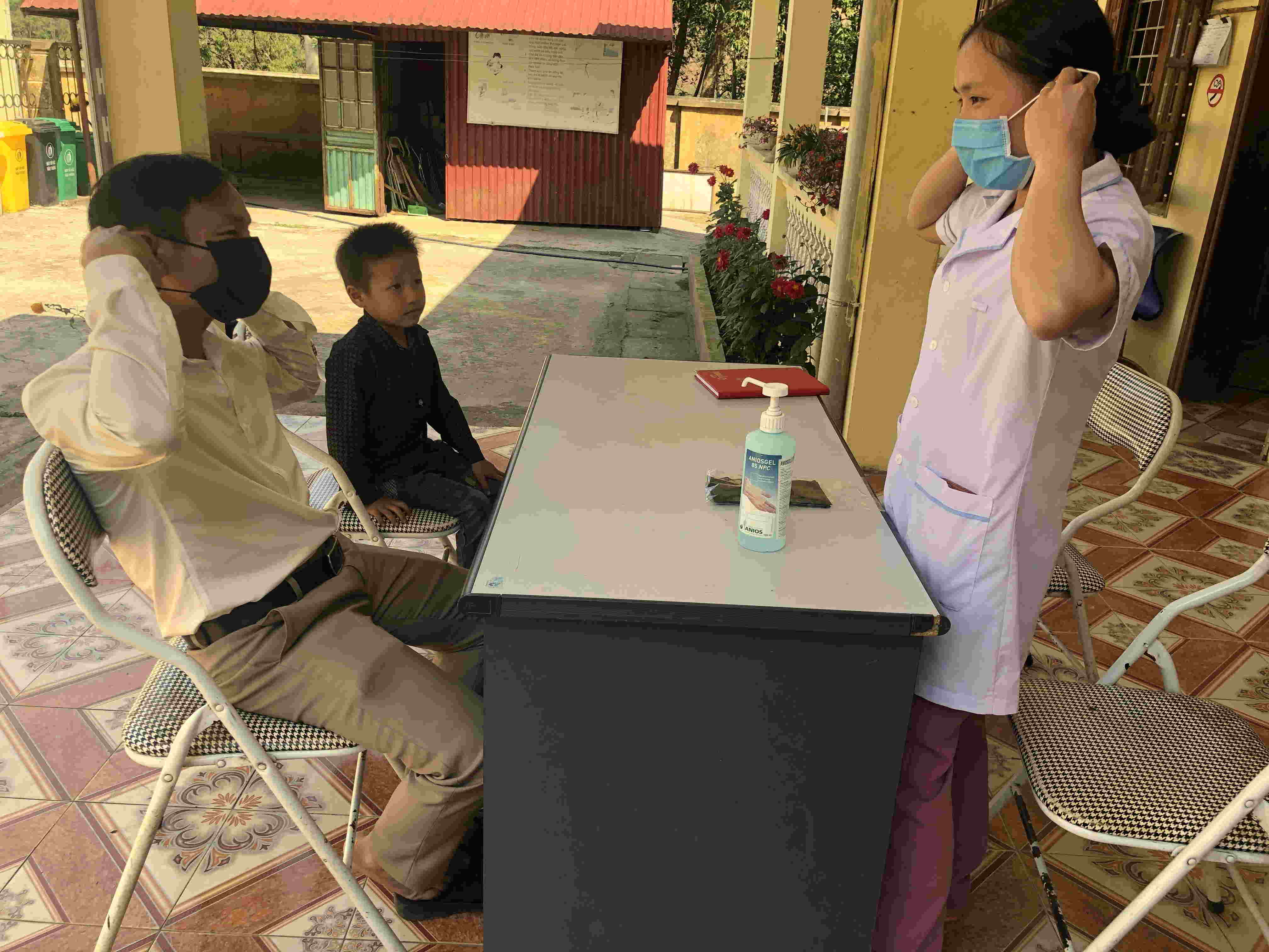 Cán bộ y tế Trạm Y tế Phìn Hồ hướng dẫn người dân cách đeo khẩu trang và rửa tay.