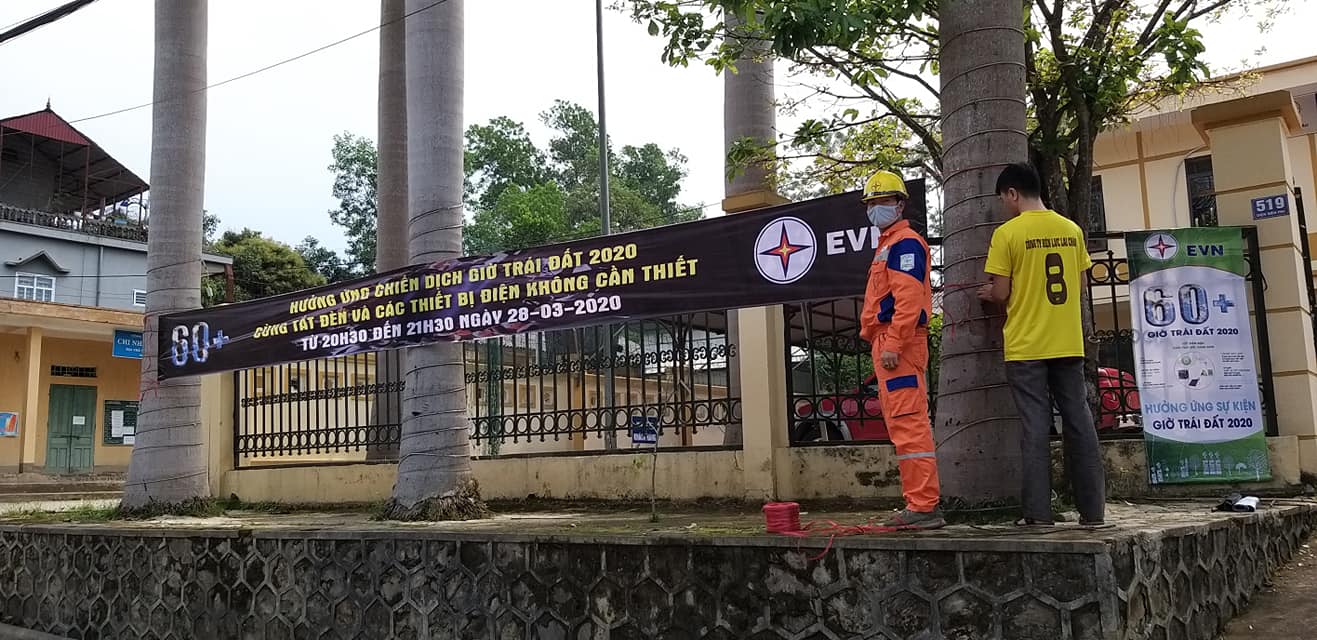 Cán bộ Điện lực Than Uyên treo băng zôn tuyên truyền giờ trái đất