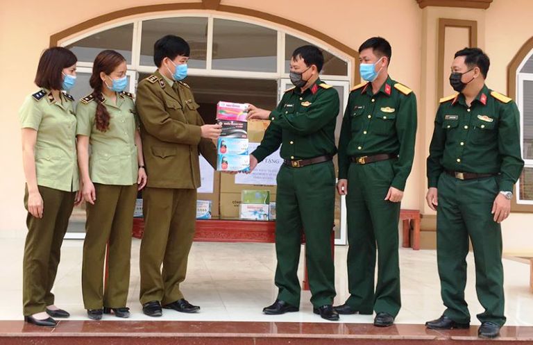 Chú thích: Cục Quản lý thị trường tỉnh trao khẩu trang y tế cho điểm cách ly tập trung tại Trường Quân sự tỉnh. 