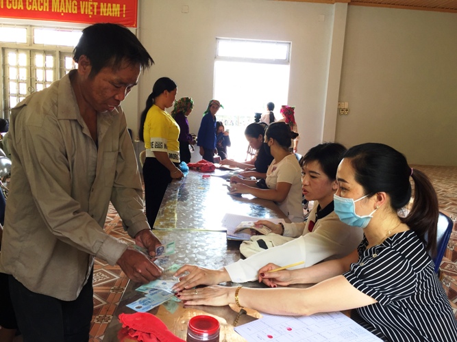 Anh Lò Văn Oan nhận tiền hỗ trợ từ đội ngũ cán bộ xã. 