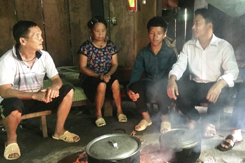 Đồng chí trưởng bản đến thăm hỏi em Giàng A Chu (thứ 2 từ phải sang). 