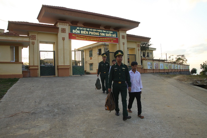 Cán bộ, chiến sĩ dắt các em học sinh được đơn vị nhận nuôi theo chướng trình “ Con nuôi của đồn” đến trường