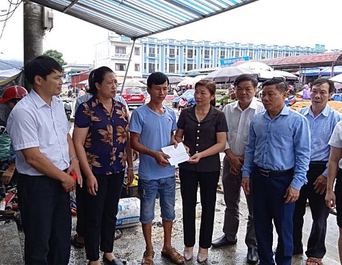 Đại diện Ban Cứu trợ thành phố Lai Châu trao tiền hỗ trợ cho hộ bị hỏa hoạn.