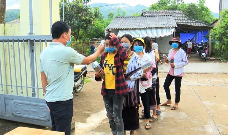 Học sinh trường THCS Mường Khoa đeo khẩu trang, đo thân nhiệt trước khi vào lớp trong đợt dịch đầu năm học 2020 – 2021. 