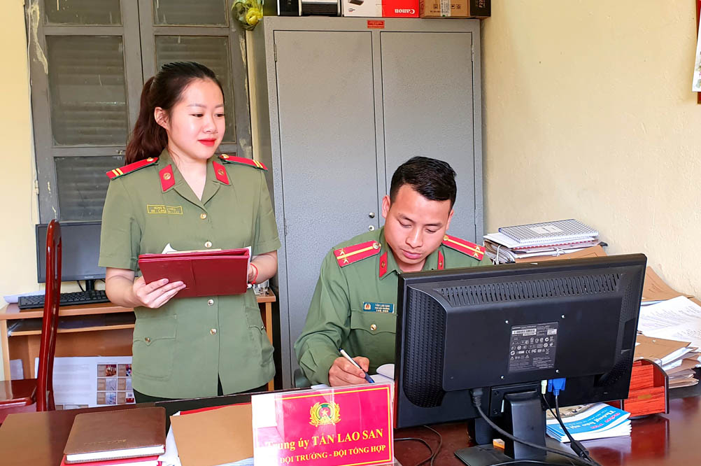 Trung úy Tẩn Lao San trao đổi công việc với đồng nghiệp.