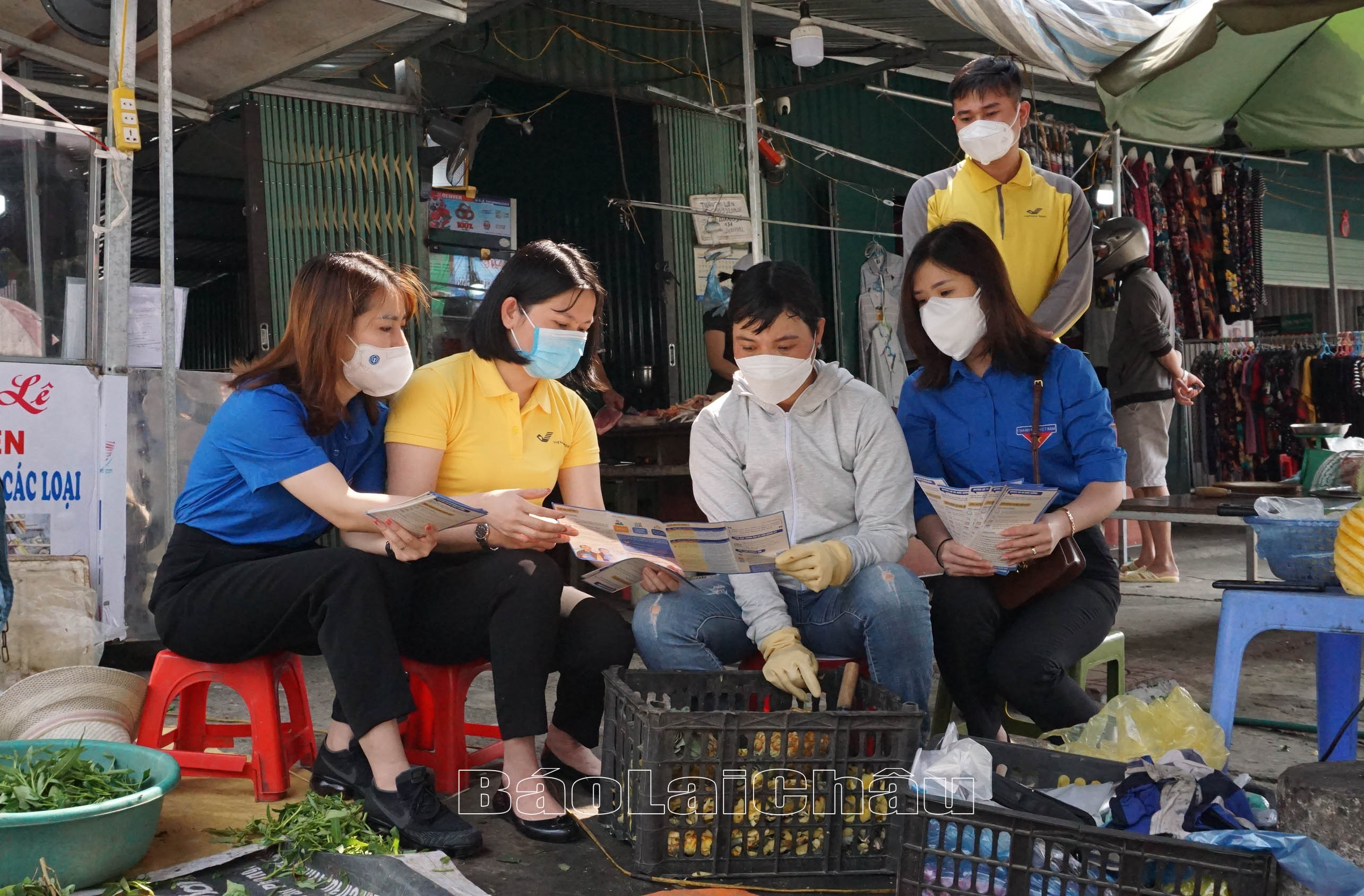 Đoàn viên, thanh niên Bưu điện tỉnh và BHXH tỉnh tư vấn BHXH tự nguyện cho người dân buôn bán tại Chợ trung tâm thương mại (thành phố Lai Châu).