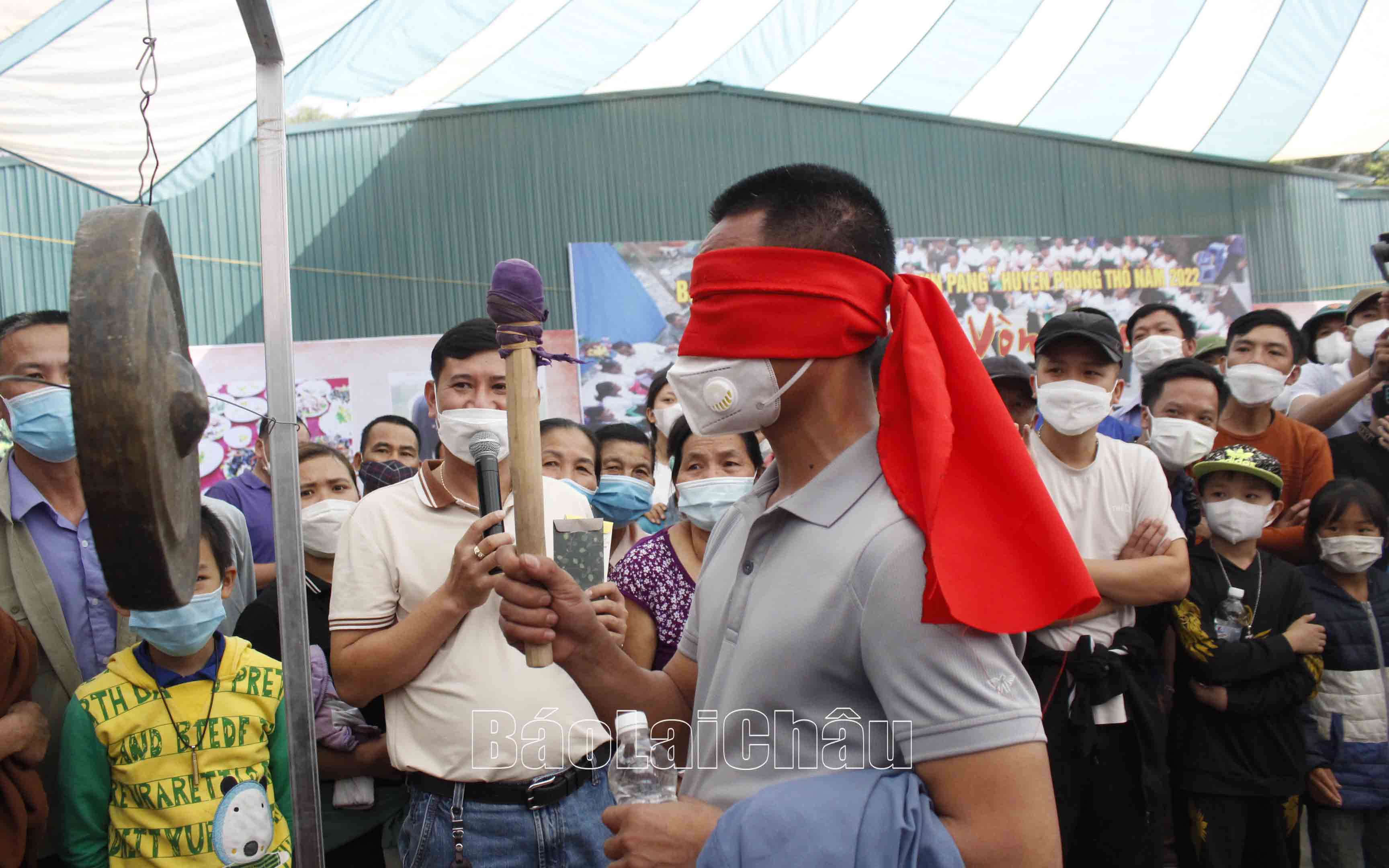 Du khách tham gia trò chơi bịt mắt gõ chiêng. 