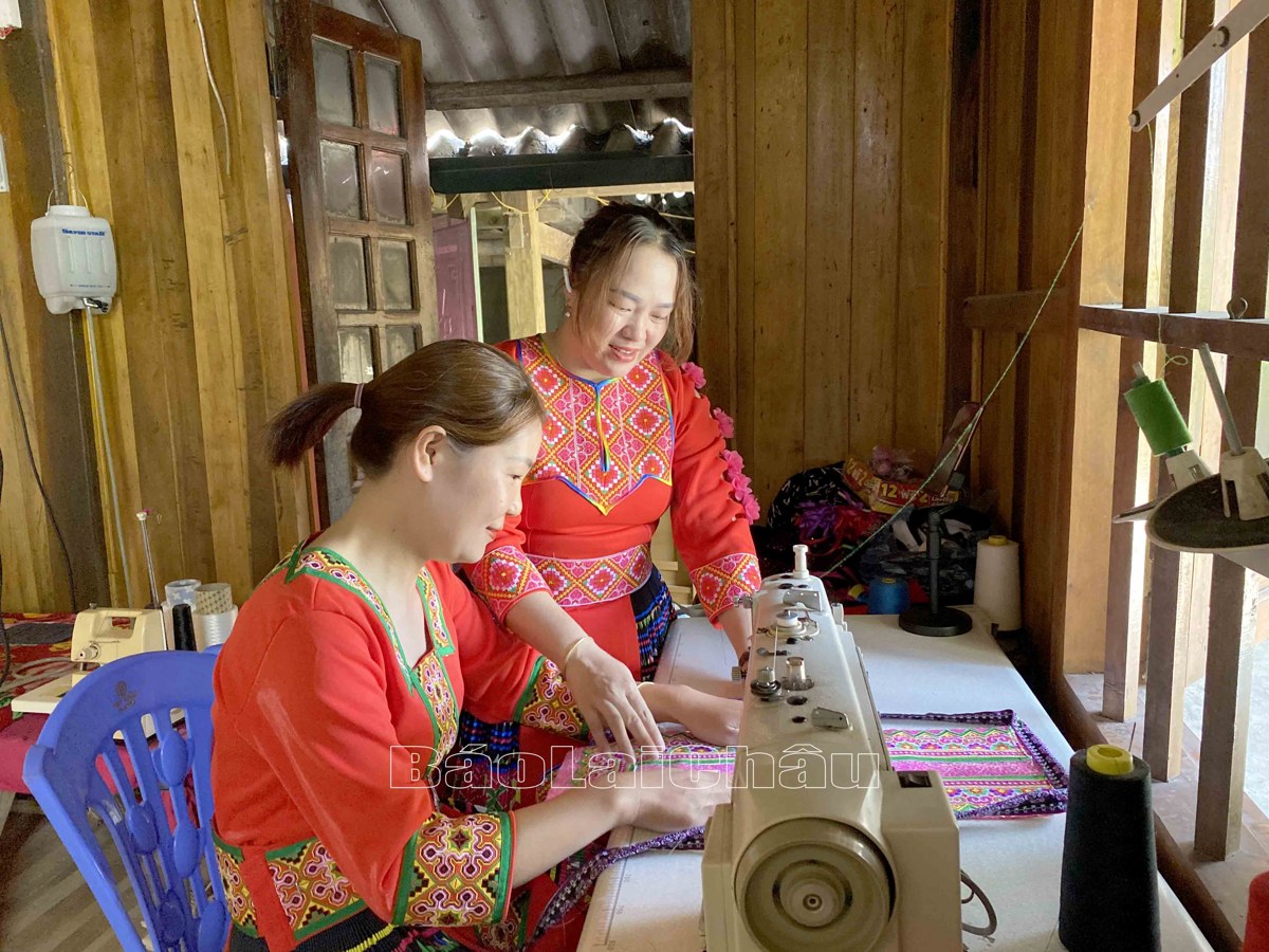 Đảng viên Vàng Thị Sua – Chi bộ Chu Va 12 (Xã Sơn Bình, huyện Tam Đường) hướng dẫn chị em may trang phục dân tộc Mông.