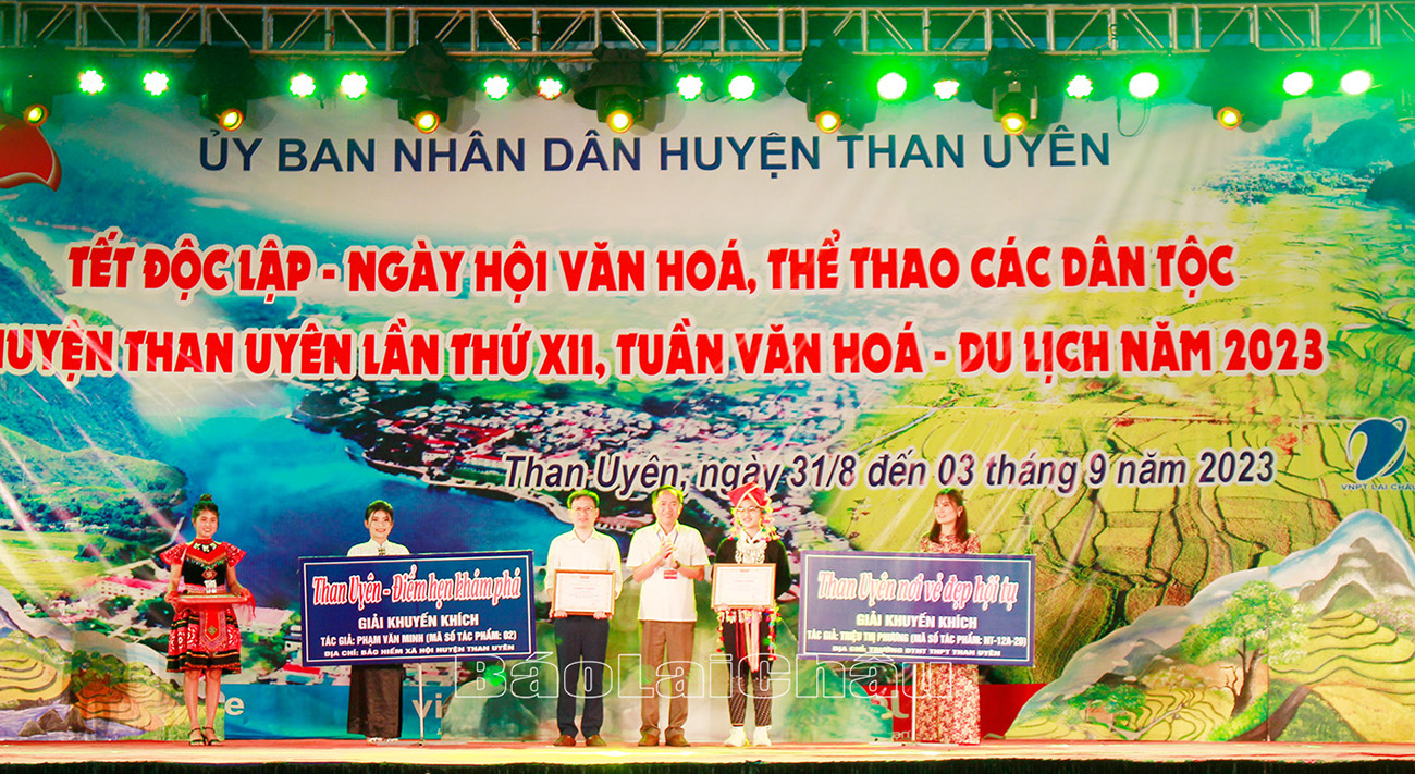 Đồng chí Trần Quang Chiến - Phó Chủ tịch UBND huyện Than Uyên trao 2 giải cho các tác giả đạt giải khuyến khích về sáng tạo khẩu hiệu.