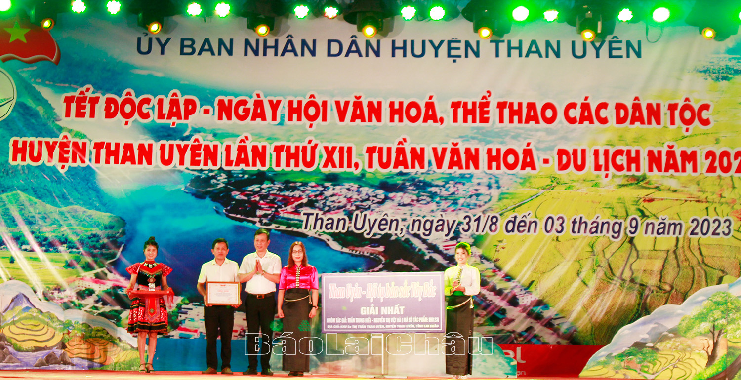 Đồng chí Nguyễn Văn Thăng - Phó Bí thư Huyện ủy, Chủ tịch UBND huyện Than Uyên trao giải nhất cho nhóm tác giả Trần Trung Hiếu, Nguyễn Thị Việt Hà Khu 5A (thị trấn Than Uyên) với khẩu hiệu “Than Uyên - Hội tụ bản sắc Tây Bắc”.