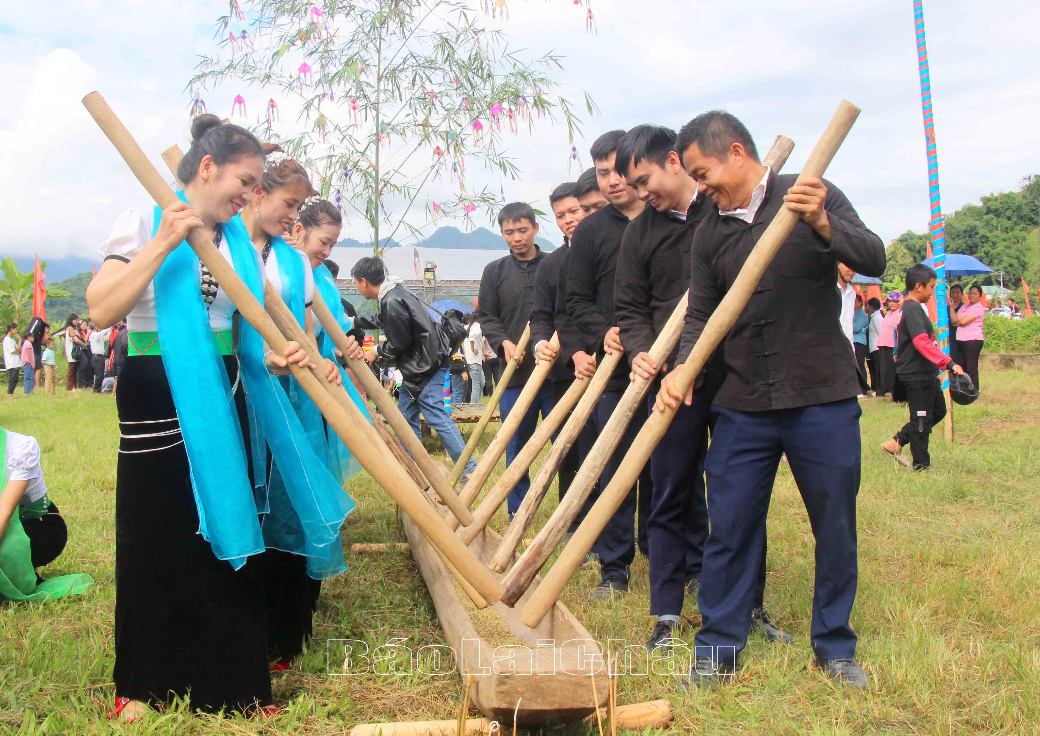 Các chàng trai, cô gái giã gạo mới làm cốm.