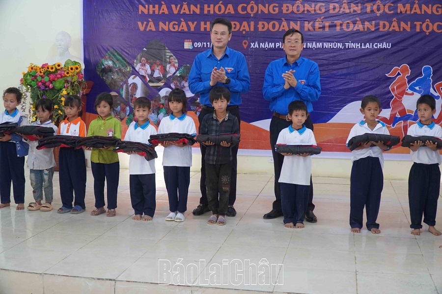 Anh Nguyễn Kim Quy và đồng chí Lù Văn Quân tặng quà cho học sinh có hoàn cảnh khó khăn của xã Nậm Pì.