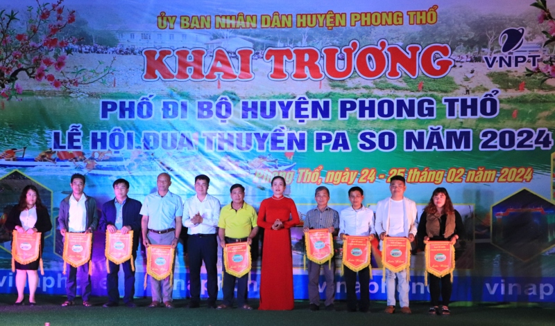 Đồng chí Mai Thị Hồng Sim – Phó Chủ tịch UBND huyện Phong Thổ trao cờ lưu niệm cho các đội về tham dự lễ hội đua thuyền. 
