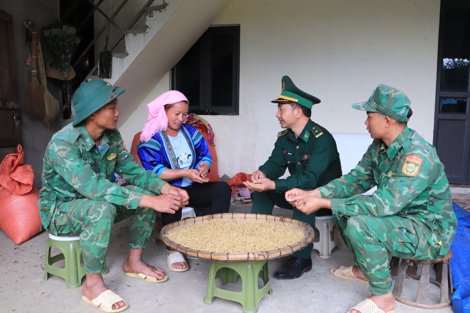 Cán bộ, chiến sĩ Đồn Biên phòng Dào San hướng dẫn hội viên phụ nữ xã Dào San cách bảo quản nông sản sau thu hoạch.