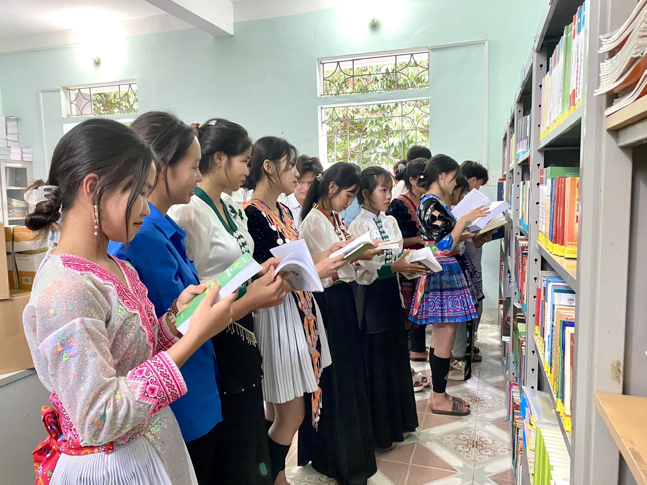 Các em học viên, sinh viên tham quan tủ sách HOU và đọc sách tại thư viện.