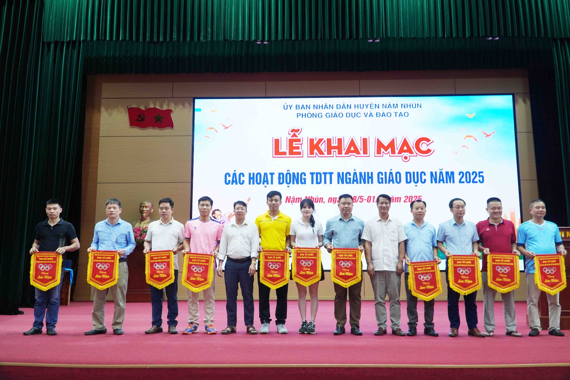 Đại diện các đoàn vận động viên nhận cờ lưu niệm từ ban tổ chức.