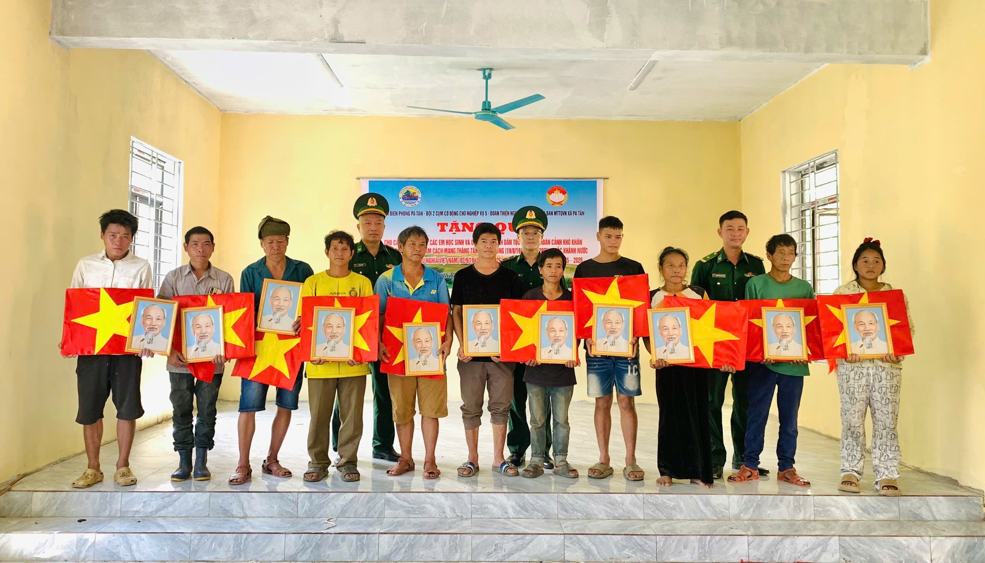 Đại diện Đồn Biên phòng Pa Tần trao tặng bộ cờ Tổ quốc và ảnh Bác Hồ cho người dân bản Mảng xã Pa Tần.