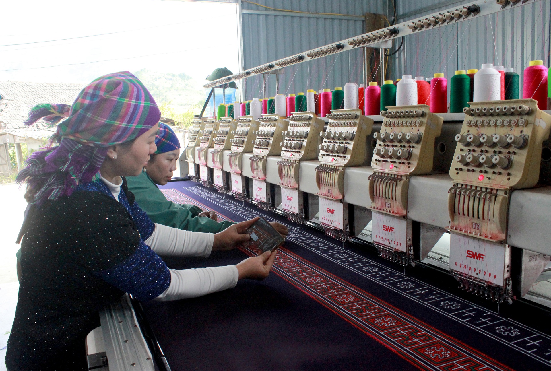 Chị Má Thị Mảo (bên trái), tổ dân phố Gia Khâu 2, phường Đoàn Kết đầu tư máy móc, mở rộng sản xuất thổ cẩm gắn với quảng bá sản phẩm trên nền tảng số.