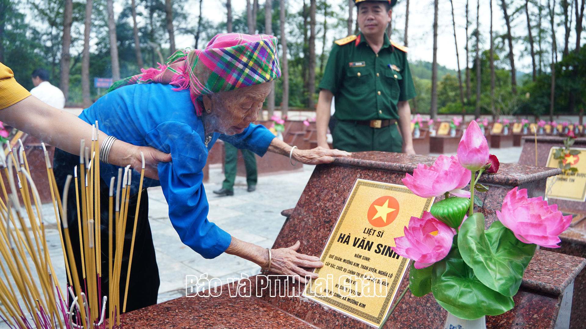 Bà Hà Thị È – con đẻ liệt sĩ Hà Văn Sinh xúc động trước phần mộ của cha tại nghĩa trang Than Uyên. 